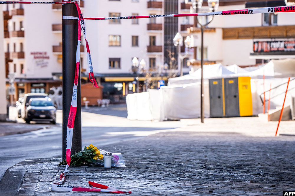 Flowers and candles laid on the ground near the bar Le Constellation following a fire that ripped through the venue in Crans-Montana, during New Year's Eve celebrations