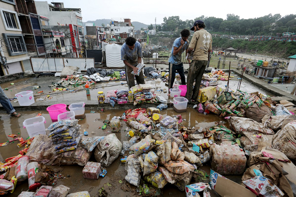 Residents salvage belongings after flash flood and landslide triggered by heavy rains wreaked havoc at Rajouri district in India's Jammu region on July 19, 2026.