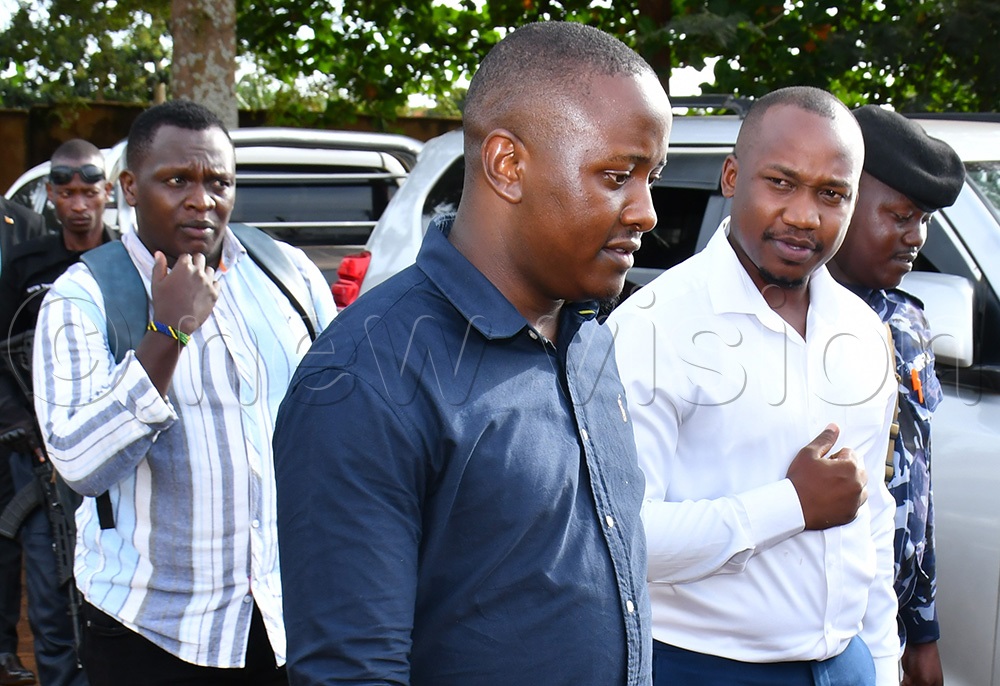 Donald Francis Wangoli (2nd right), a staff surveyor, and Jovan Woniala (left), a graduate trainee at the Ministry Zonal Office being led by Policemen to a vehicle to be taken to the Jinja regional IGG office for further investigation after their arrest on April 15th. (Photo by Donald Kiirya)