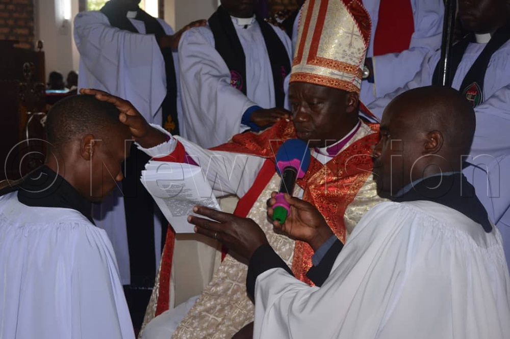 Bishop of West Ankole Anglican Diocese, Rt. Rev. Johnson Twinomujuni, praying for a church member. (Credit: Bruno Mugizi)