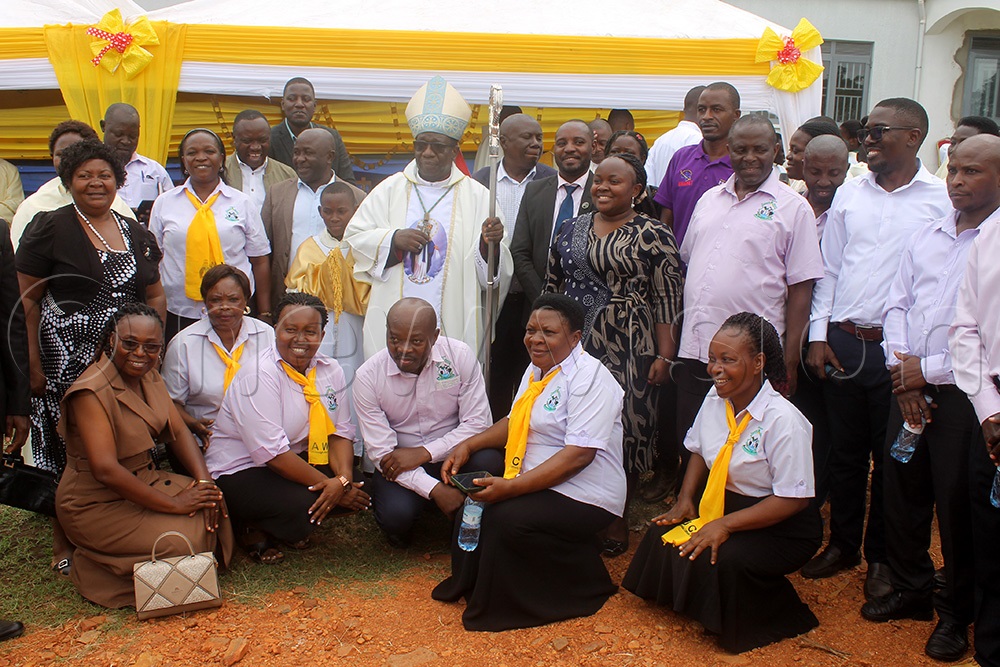 Bishop Francis Aquirinus Kibira poses for a photo with staff of Kasese District local government. (Photo by Samuel Amanyire)