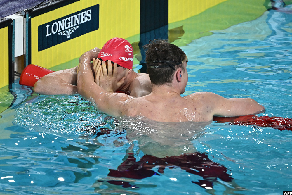 Gold medallist England's Brodie Williams (R) consoles teammate England's Luke Greenbank