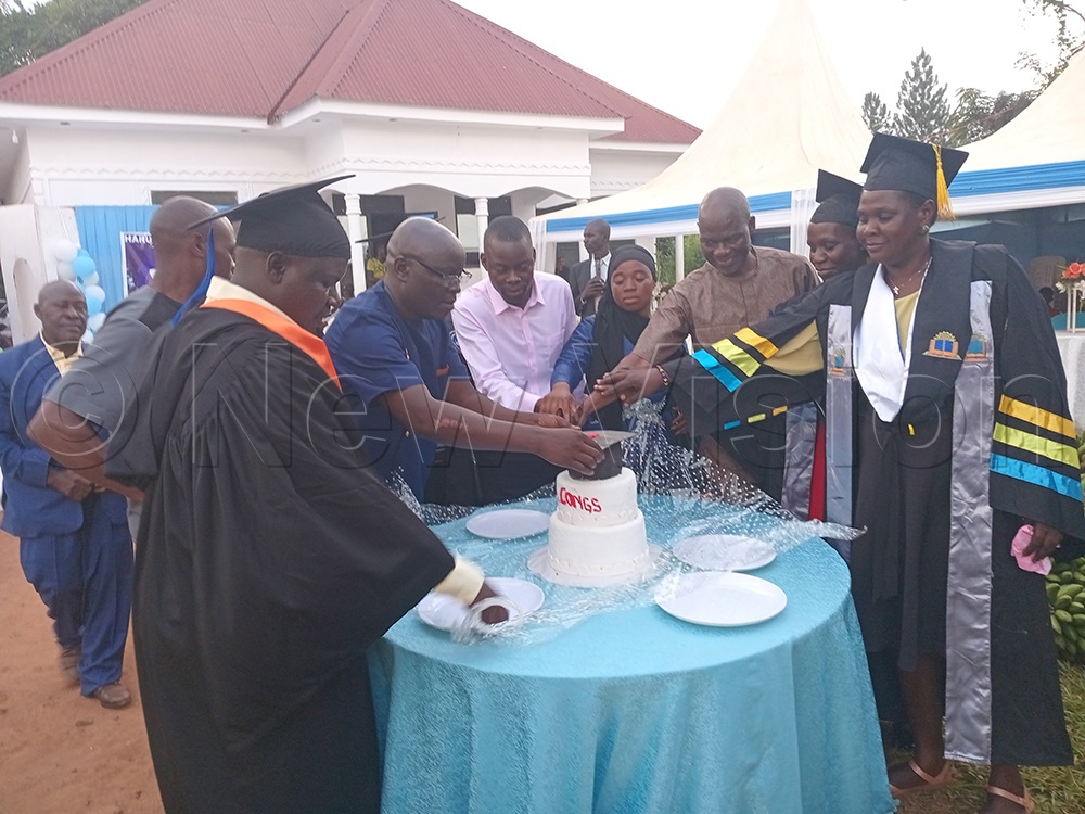 Nkutiire (centre) and other guests while cutting cake at the event. (Credit: Ivan Wakibi)