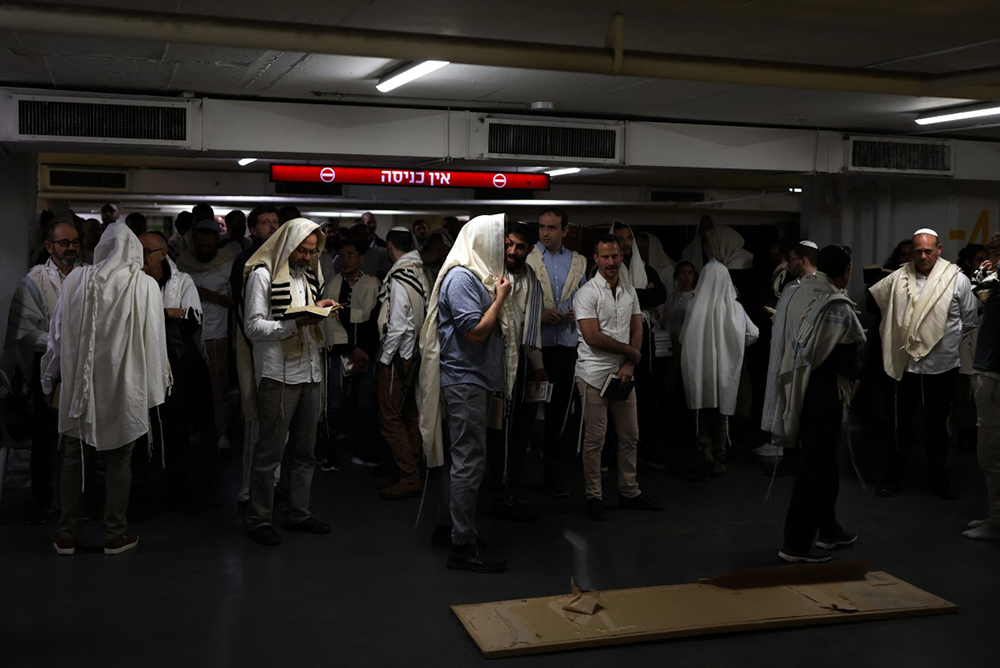 Jews pray as they take shelter in Tel Aviv on February 28, 2026. The Israeli military said its strikes on Iran, in coordination with the United States, targeted dozens of military sites and followed months of joint planning between the allies. (AFP)