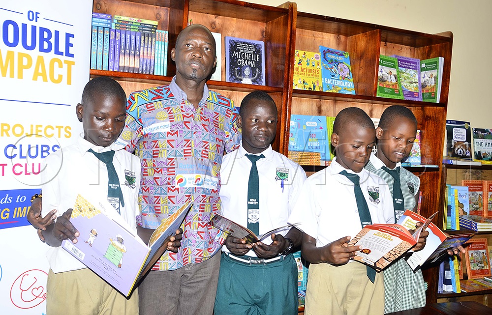 Ken Mugisha, Past District Governor, poses with learners during the commissioning of a school library at Kansanga Primary School in Makindye Division on August 7, 2026. (Photo by Juliet Kasirye)