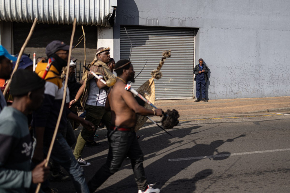 A man looks on as protesters march past him during a protest march against undocumented migrants in Springs, Ekurhuleni, on June 8, 2026. (AFP)