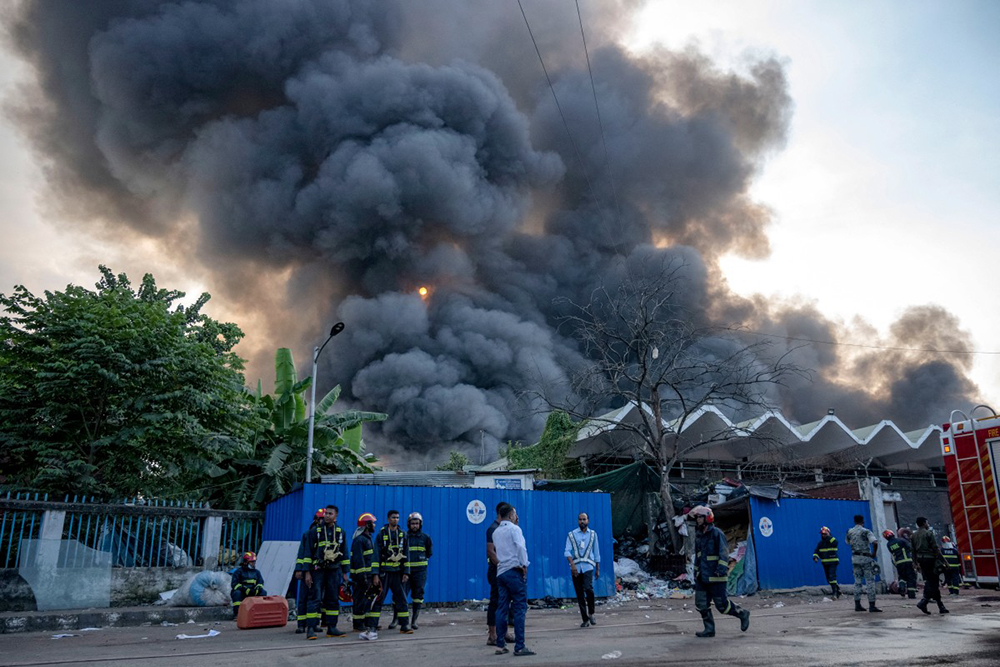 Smoke rises into the sky as firefighters try to extinguish a fire that broke out in the cargo section of Hazrat Shahjalal International Airport in Dhaka on October 18, 2025. A large fire swept through the cargo terminal of Bangladesh's main international airport in Dhaka on October 18, forcing authorities to suspend all flights, officials said.