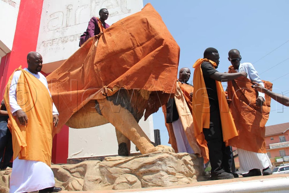 The statue was covered as residents and kingdom officials looked on, marking one of the first visible public symbols of mourning for the late king.