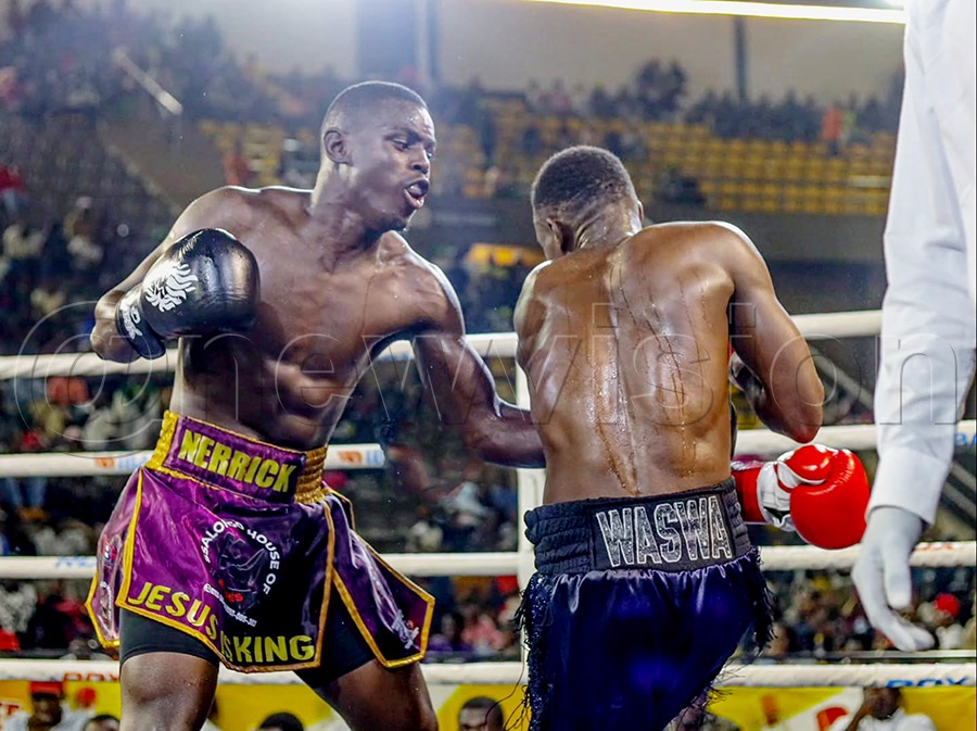 Nerrick Bulabe Tumusiime (left) lands a body punch on Depark Mawanda during their light middleweight contest at Hamz Stadium.  Photo by FRED KISEKKA