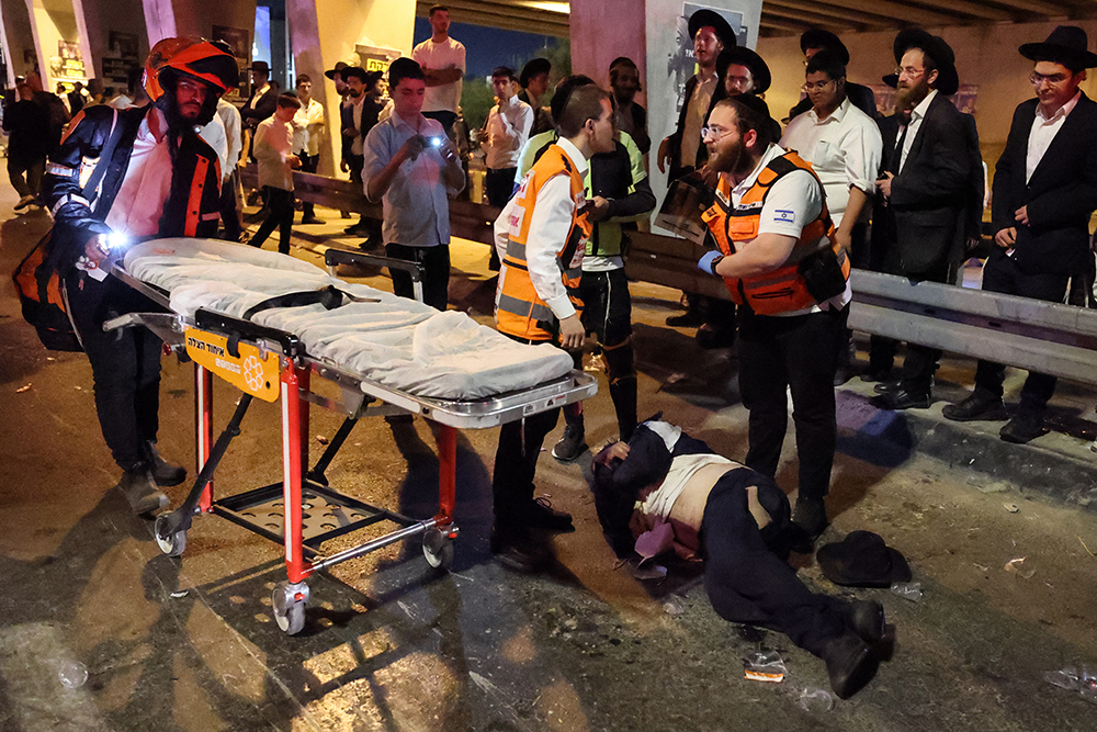 Israeli medics treat a man who was injured as police dispersed ultra-Orthodox Jews during a protest against their conscription for compulsory military service near the center of the Israeli city of Bnei Brak on October 29, 2026. (Photo by AFP)