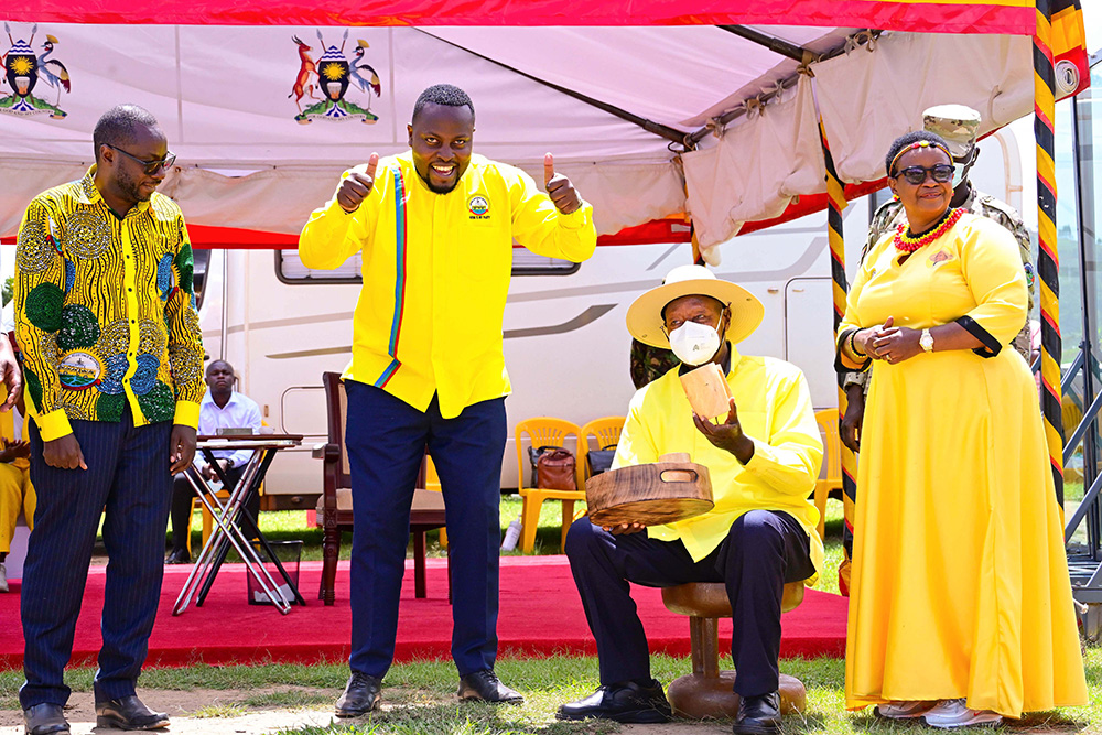 President Museveni tries out his chair and other gifts presented to him by Rukiga district NRM flagbearers Kiconco Katabazi (L) Simon Mutebi (C) and Sylvia Arinaitwe (R) during a campaign rally in Rukiga district. (PPU Photo)