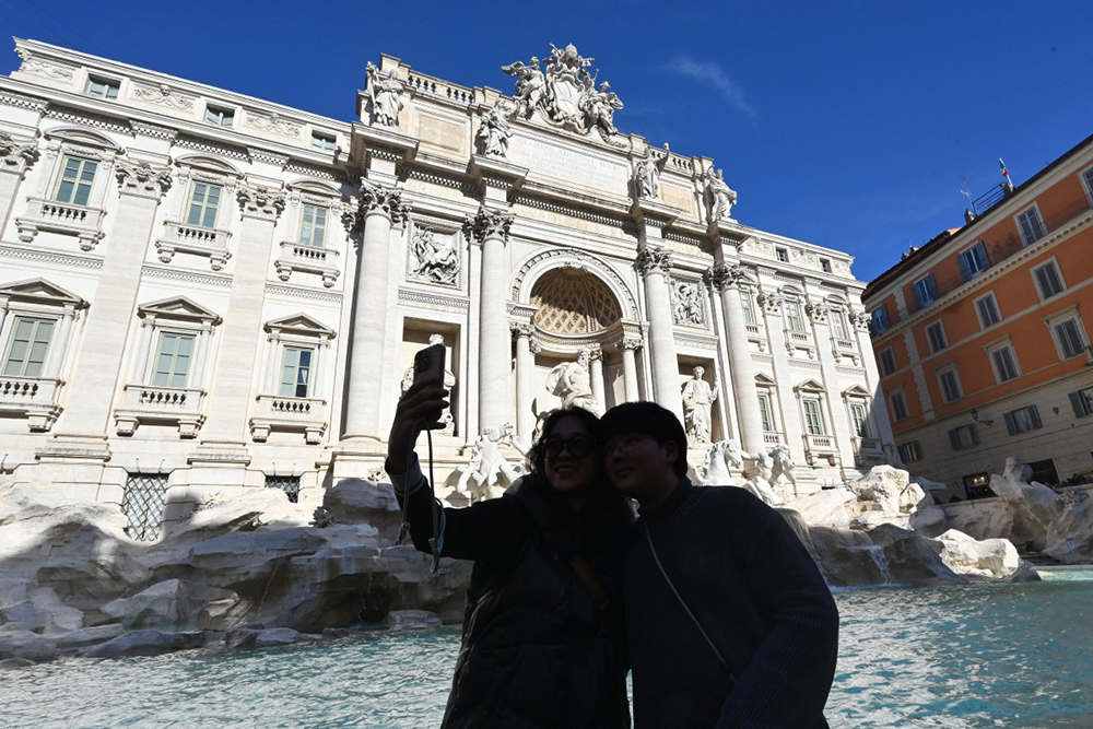 Visitors pose for a picture in the viewing area of the Trevi Fountain in Rome, after the city introduces a two-euro paid entry to the fountain, on February 2, 2026. 