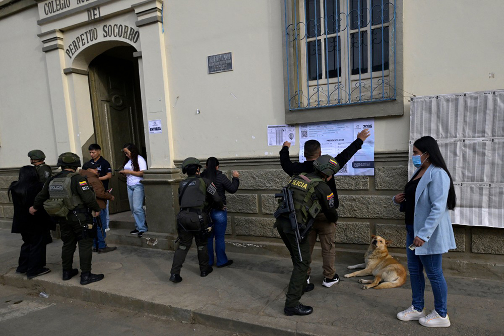 Police officers frisk voters outside a polling station during the presidential election in Silvia, Cauca department, Colombia, on May 31, 2026.