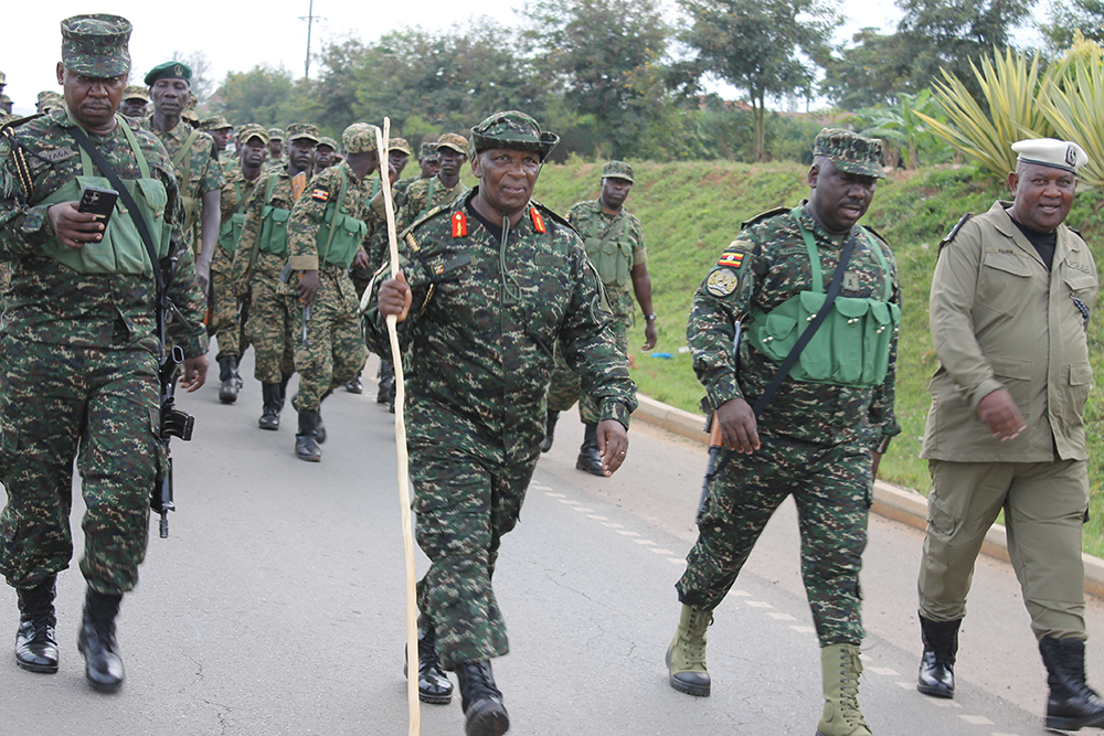 The UPDF 2 Infantry Division Commander, Maj. Gen. Paul Muhanguzi (holding a stick), UPDF 2 Infantry Public Relations Officer, Maj. Kiconco Tabaro (2nd from right in front), with other officers, during the 30-kilometre march, which was conducted in different parts of Mbarara City.