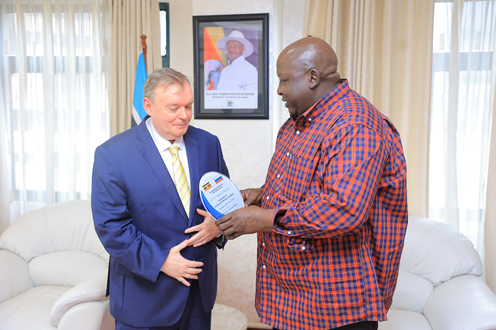 Minister Oryem handing over plaque to ambassador Semivolos. (Courtesy)