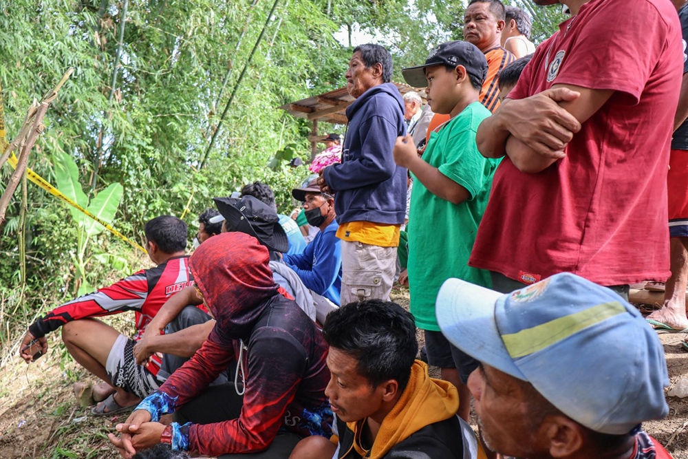 Families of victims wait at the holding area after a landslide at the landfill in Barangay Binaliw, Cebu City on January 11, 2026. 