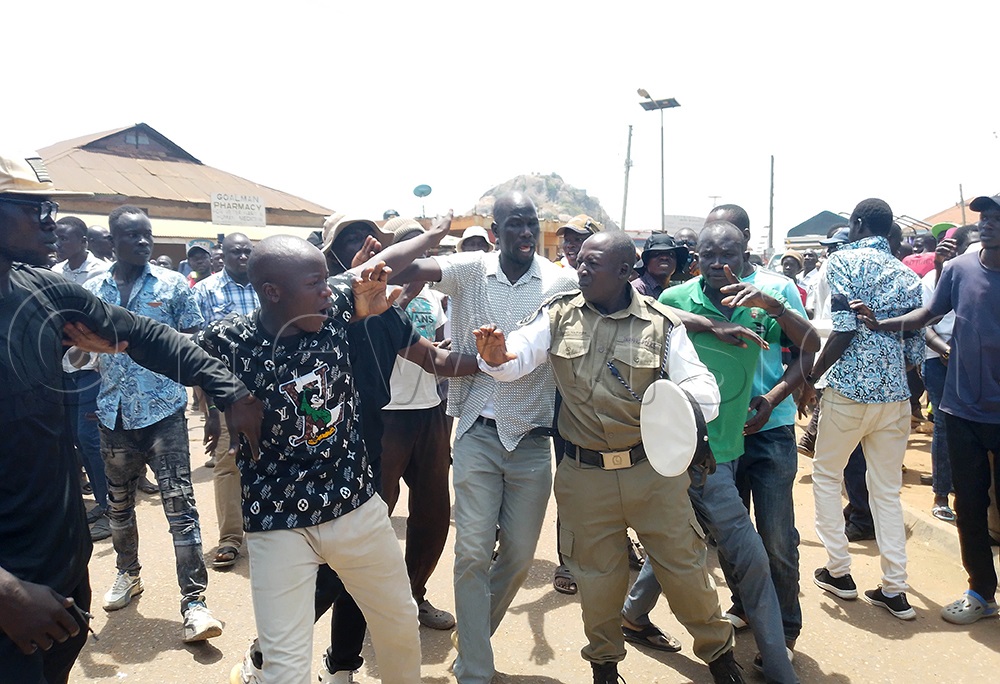 FDC supporters wrestling with a Police traffic officer during the demonstration. (Photo by Godfrey Ojore)