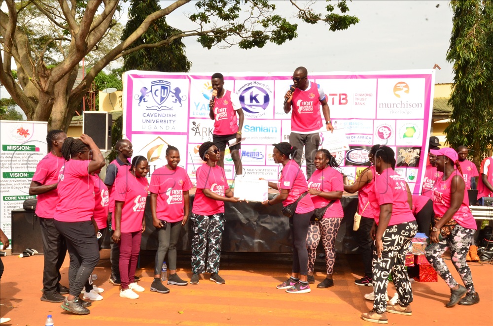 Officer in charge of palliative care at Ministry of Health Dr Miriam Ajambo handing over a certificate of appreciation to participants of the Fight Women Cancer run.