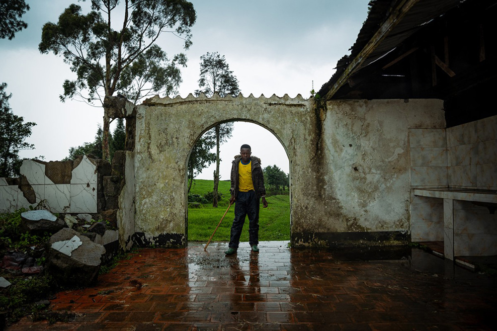A young farmer takes poses in a former hotel in Ruvunda that was bombed by a Congolese army drone in December 2023 on the suspicion that was used as a position by the M23 rebel group, in Mushaki on November 12, 2025. (Photo by Jospin Mwisha / AFP)