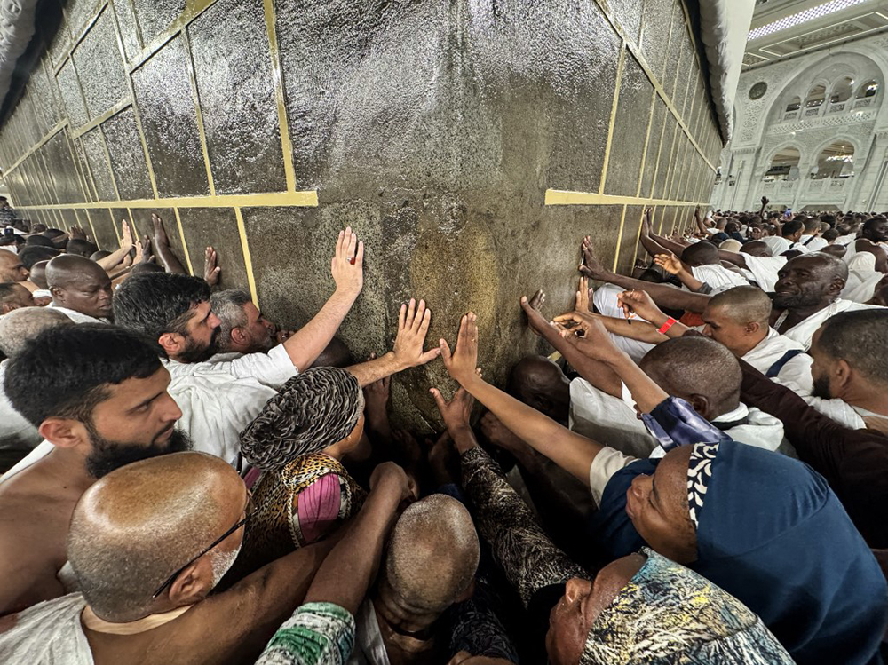 Pilgrims pray while touching the walls of the Kaaba during the Hajj pilgrimage before Eid al-Adha in Mecca, Saudi Arabia on May 23, 2026. (Credit: AFP)
