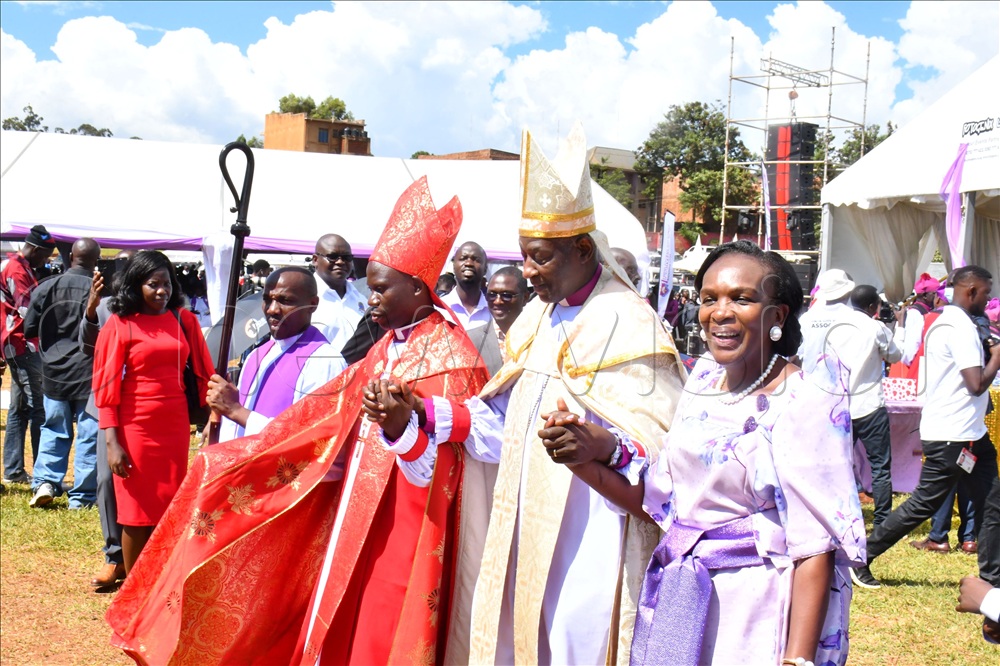 The Archbishop of Church of Uganda the Most Rev. Stephen Kazimba Mugalu (2nd right) holding hands of the new Busoga Diocesan Bishop Rt. Rev. Canon. Associate Prof. Dr. Grace Lubaale (middle) and his wife Clare Lubaale (right) after being consecrated and enthroned as Bishop at Kyabazinga Stadium in Jinja City on Sunday.