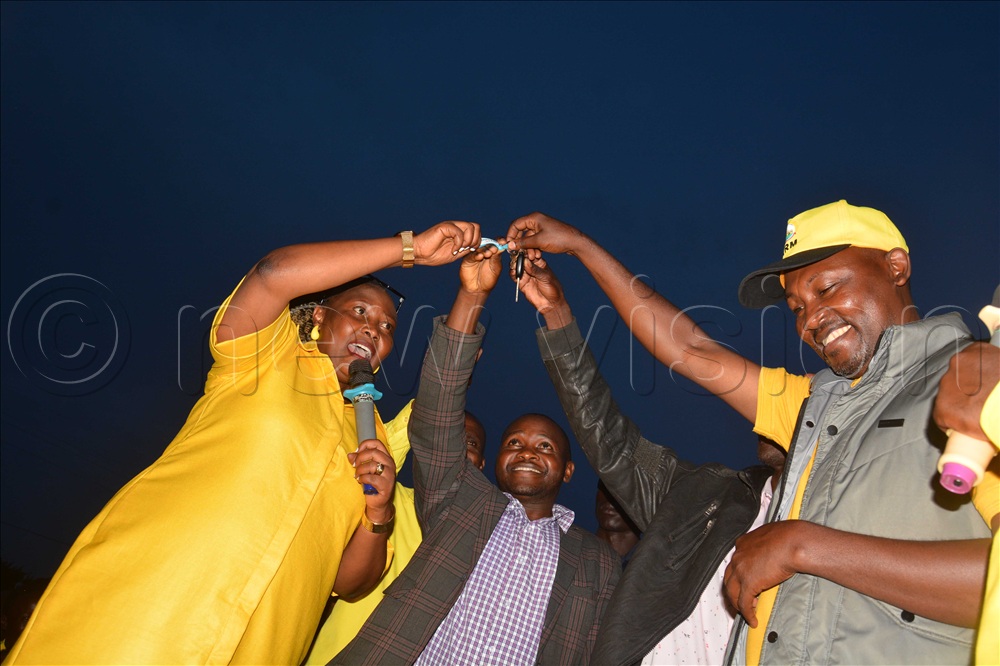he senior presidential advisor on agriculture and rural development Peace Rugambwa (left) handsover a key of the ambulance worth sh180m donated by President Yoweri Museveni to clinical officer of Bwambara Health Centre III Francis Muhumuza (centre) and NRM vice chairperson for Rukungiri Ambrose Kibuuka during the handover ceremony at Bwambara grounds in Rukungiri district on Saturday November 15, 2025.
