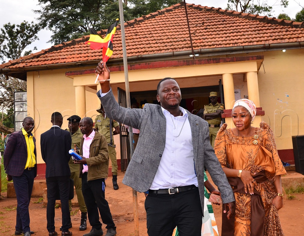 Shaban Okumu flanked by his wife, waves the Uganda flag after scrambling for the symbol during his nomination to vie for Butembe county in Jinja district on Wednesday. (Photo by Jackie Nambogga)