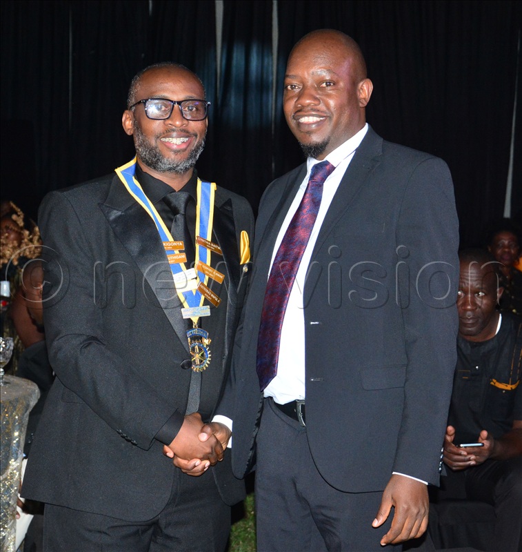 The 14th President of Rotary Club of Kampala Muyenga Breeze, Joshua Gavin Wanume (L), being congratulated by his predecessor Rogers Mukalazi after being installed as the 14th President.