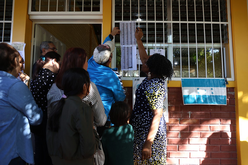 People check where to vote at a polling station during the general election in Tegucigalpa on November 30, 2025. Hondurans began voting for president on Sunday amid threats by US President Donald Trump to cut aid to the country if his preferred candidate loses. 