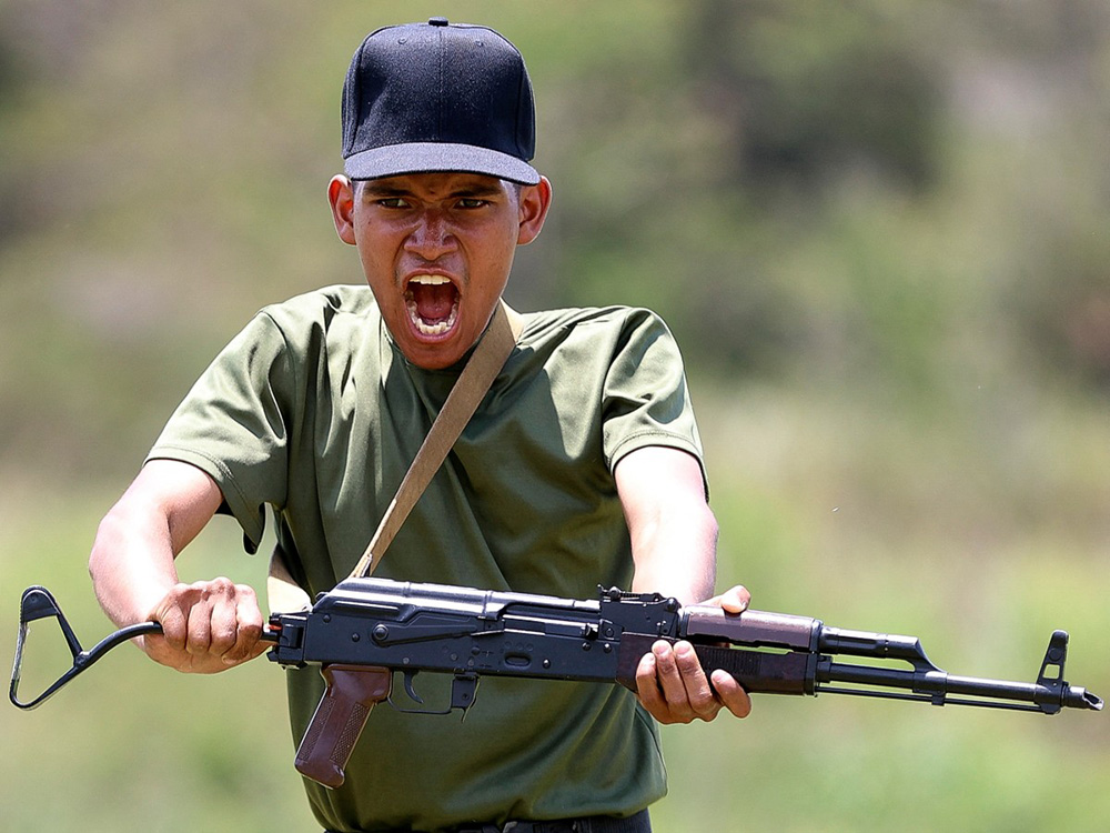 A member of the Bolivarian National Militia participates in a military training at Fuerte Tiuna in Caracas on September 13, 2025. (Photo by Pedro MATTEY / AFP)