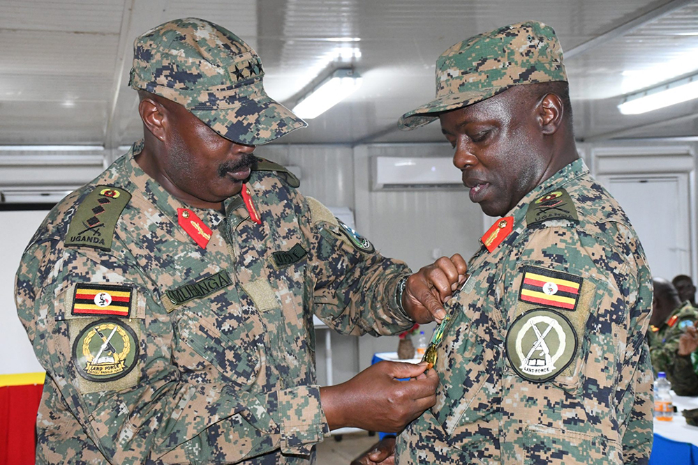 Lt Gen. Kayanga Muhanga decorating outgoing Contingent Commander, Brig. Gen. Ssemwanga Musoke. (Courtesy)