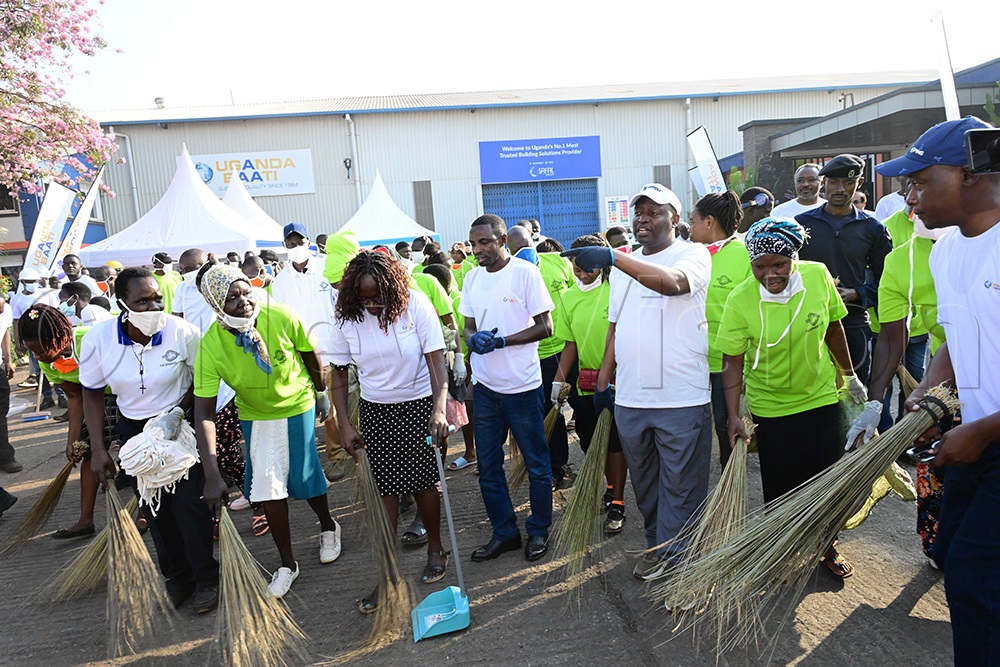State Minister for Industry David Bahati takes part in Uganda's National Cleaning Day exercise at Uganda Baati before joining the clean-up of four other industries along Mukwano Road in Kampala's Industrial Area. Also pictured are Uganda Manufacturers Association Executive Director Dr Ezra Muhoozi (left) and Uganda Baati Executive Director George Orodi (second right). (Credit: Eddie Ssejjoba)