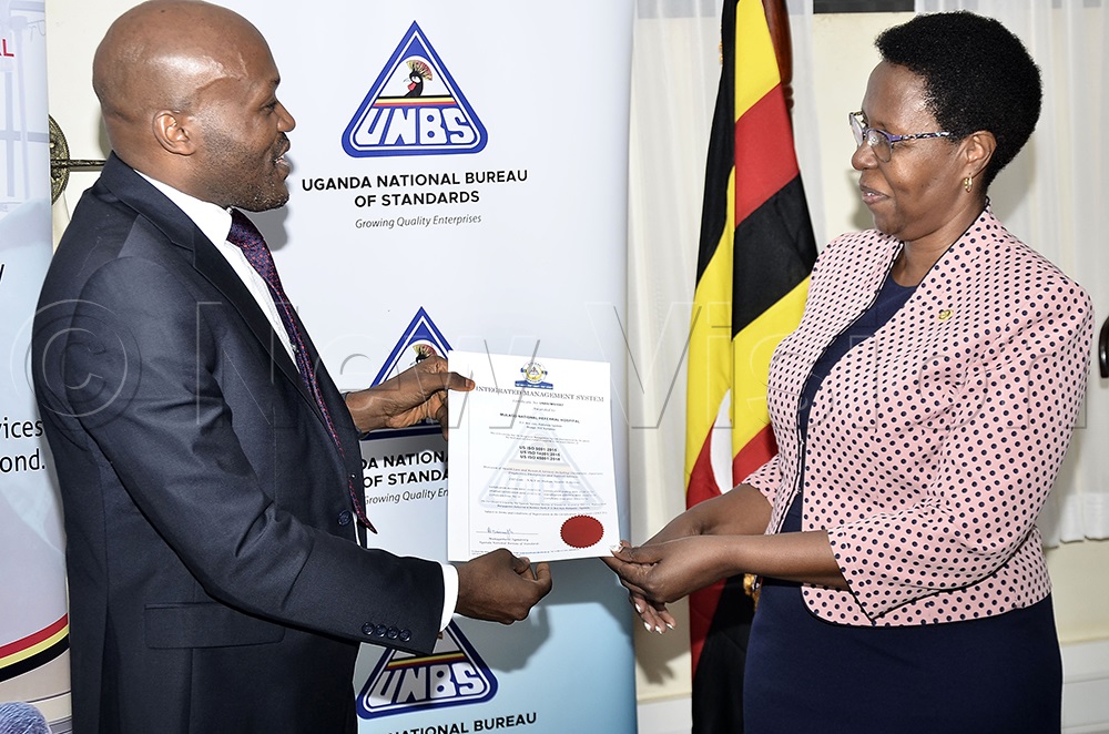 The executive Director of the Uganda National Bureau of Standards (UNBS), Eng. James N. Kasigwa (left) hands over the Integrated Management System US ISO award the Executive director of Mulago National Referral Hospital, Dr Rosemary Byanyima, at UNBS offices in Bweyogerere on Nov. 26, 2025. (Credit: Ronnie Kijjambu)