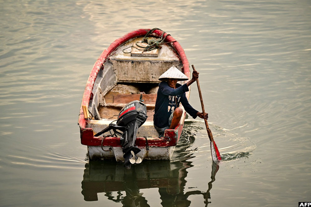 A fisherman rows a small boat toward the fishing terminal in Panama City to prepare for a new day of fishing on September 25, 2026