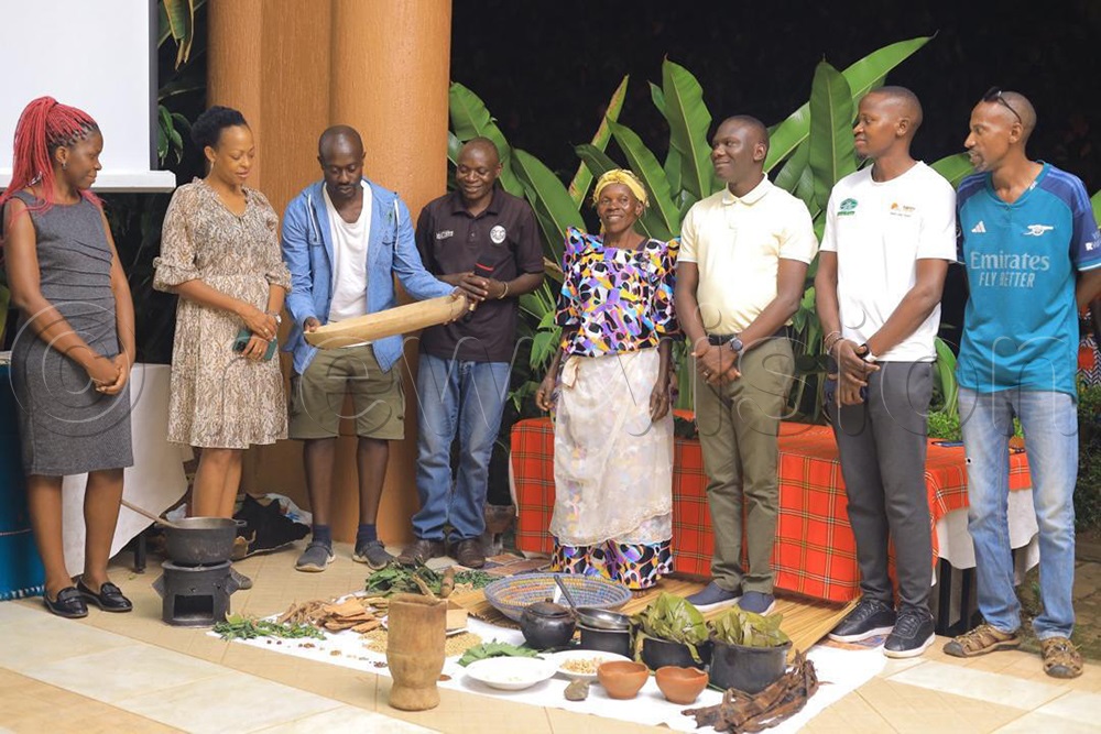 Juliana Kagwa (2nd left), the UTB CEO, together with Francis Nyende (3rd right), the marketing manager being taken through the cultural way of preparing cuisines in Eastern Uganda- Mbale. (Courtesy Photo)