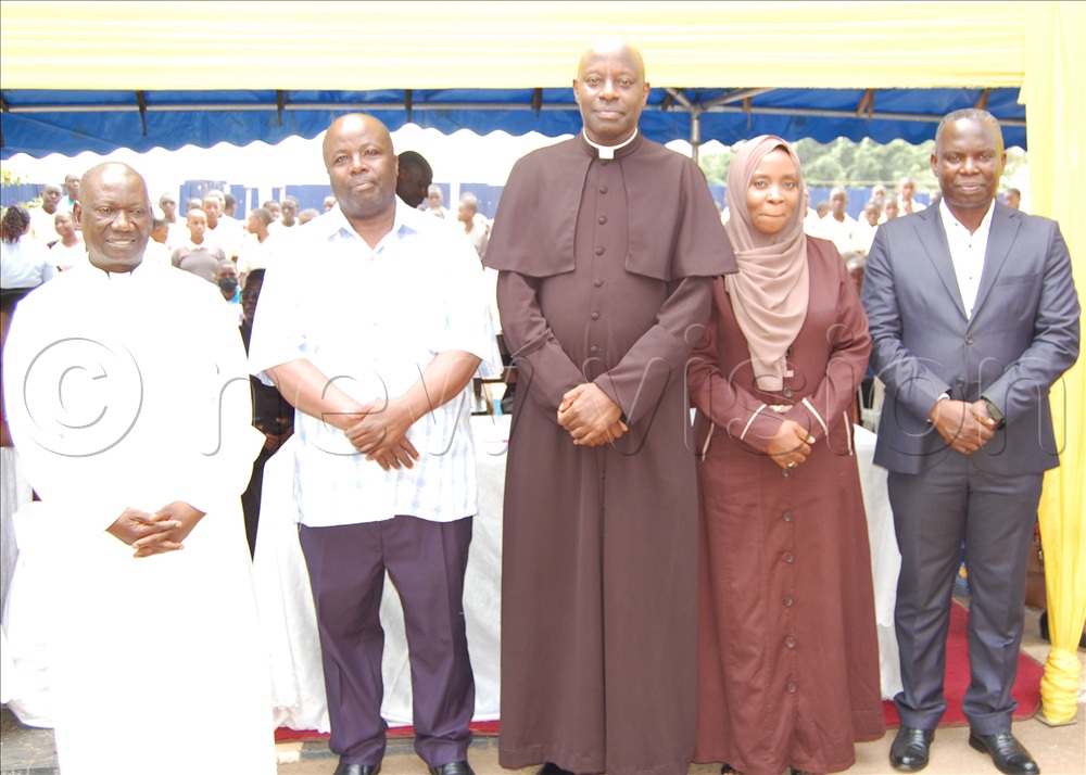 Lubaga Cathedral Centenary Organising Committee members including Msgr. Rogers Kabuye (wearing a black cassock), Fr. Achilles Mayanja (left), and Michael Ssebbowa Mukasa (right) sharing a photo-moment with visiting Muslim friends, Asuman Ssemakula (second-left) and counsel Mariam Obed Lutale (fourth-left), who donated sh500,000. 