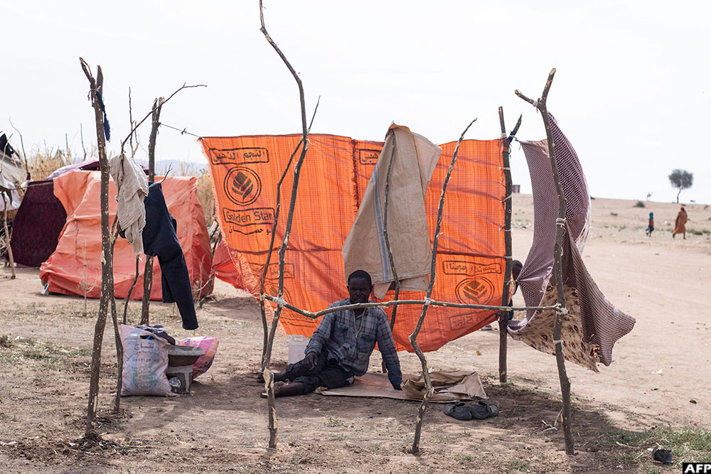 A displaced Sudanese man who fled El-Fasher after the city fell to the Rapid Support Forces (RSF), sits in a makeshift shelter in the Um Yanqur camp, located on the southwestern edge of Tawila, in war-torn Sudan's western Darfur region on November 3, 2025.