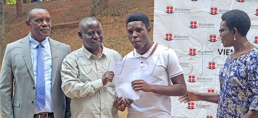 Mohammed Kakiika (left), the Vienna College Namugongo headteacher having a photo moment with parents and their child, one of those that excelled in recently released Cambridge exams. (Credit: Samuel Balagadde) 