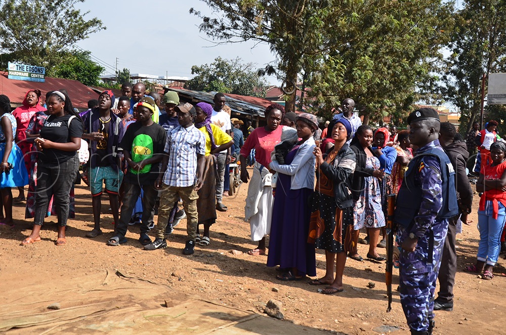 Police stand guard during the eviction process. (Photo by Jonan Tusingwire)