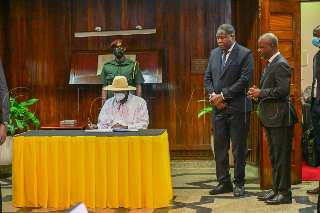 President Museveni signs in the visitors book.