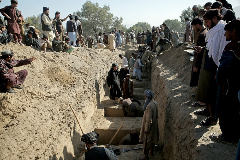Afghan residents dig mass graves for the victims, killed in an overnight Pakistani air strike, during a funeral ceremony at the Girdi Kas village in Bihsud district, Nangarhar province on February 22, 2026. (Photo by AFP)
