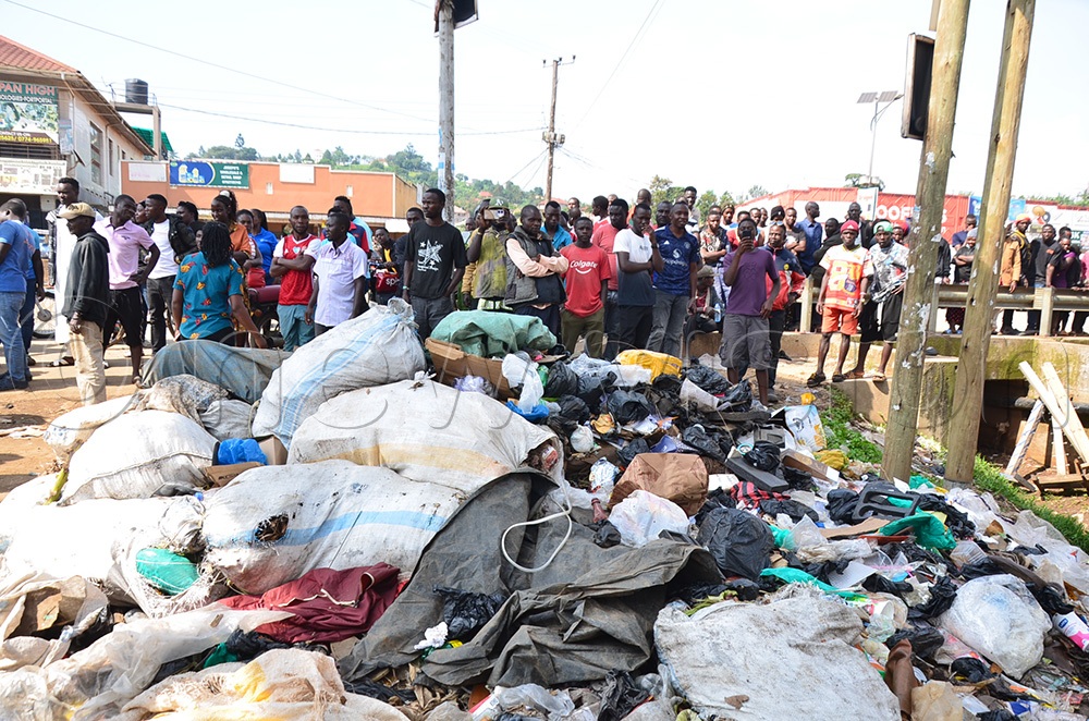 Traders look on as their stalls are confiscated by the authorities. (Photo by Jonan Tusingwire)