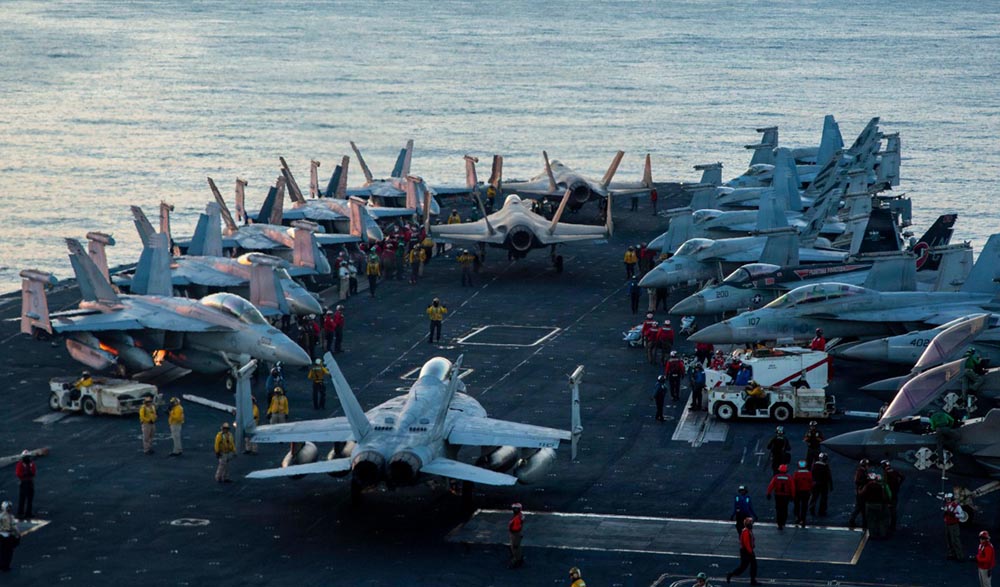 This US Navy handout photo released by US Central Command public affairs shows US sailors as they taxi aircraft to a staging point on the flight deck of Nimitz-class aircraft carrier USS Abraham Lincoln (CVN 72) in support of Operation Epic Fury, at an undisclosed location on February 28, 2026. (Credit: AFP)