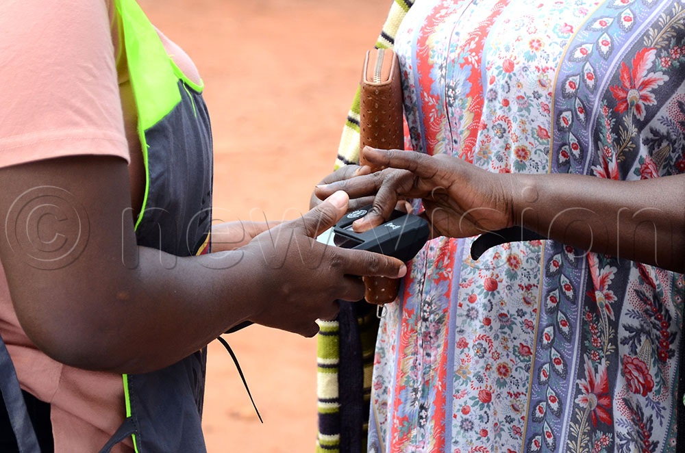 A voter putting her fingerprint on a Biometric Voter Verification Machine during the municipality, city division chairpersons and councillors elections at Younger Play Ground polling centre Lungujja, Kampala, on January 27, 2026. (Credit: Lawrence Mulondo) 