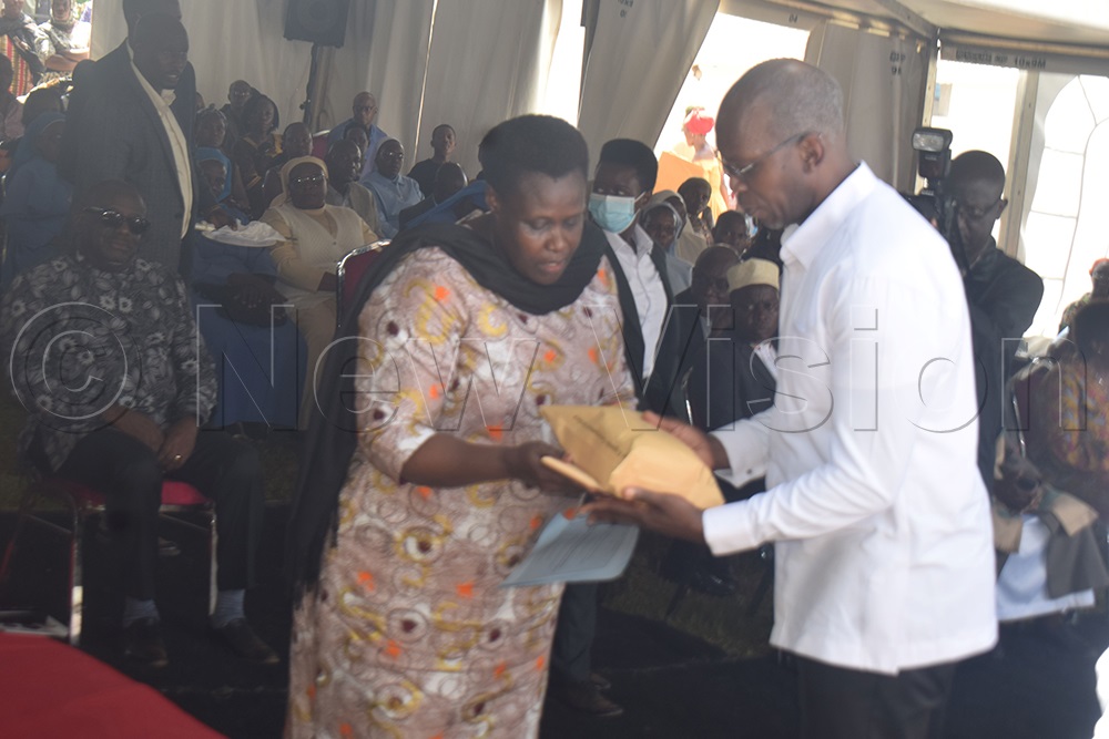 Alupo handing over condolence money to Prof. Patrick Kyamanywa, who received it on behalf of the family. (Photo by Simon Ssekidde)