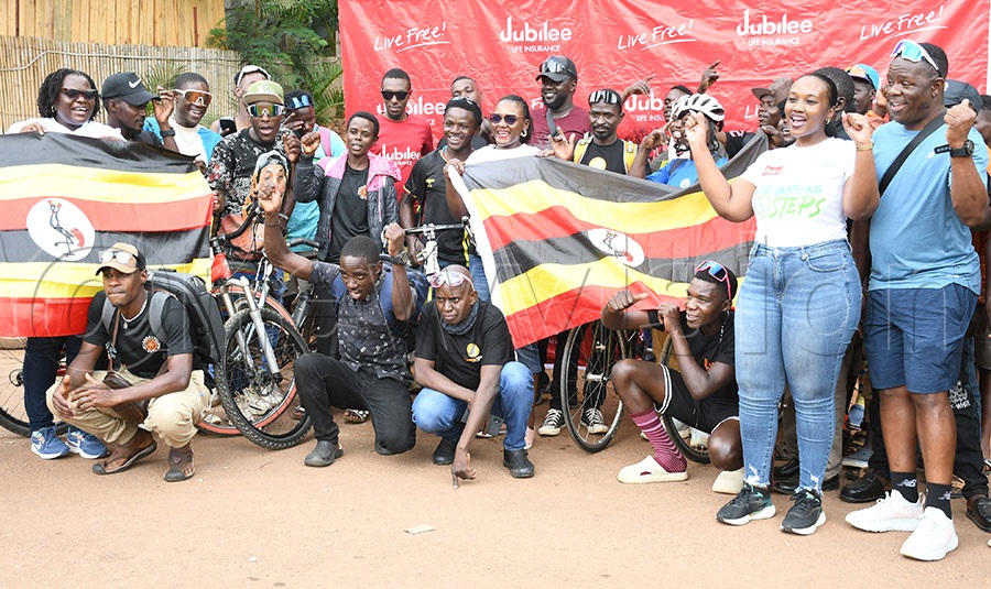 Jubilee Life Insurance Chief Distribution Officer Linda Byaruhanga (in spects-center) poses with some of the cyclists before they left for Nairobi at Lubiri Gardens, October 3, 2025. Photo by Michael Nsubuga