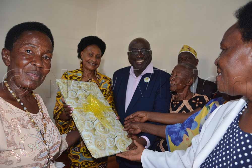 State minister for the elderly, Jaqueline Mbabazi (2nd L), receives a gift from the elderly person's leaders of Hoima City. (Credit: Peter Abaanabasazi)
