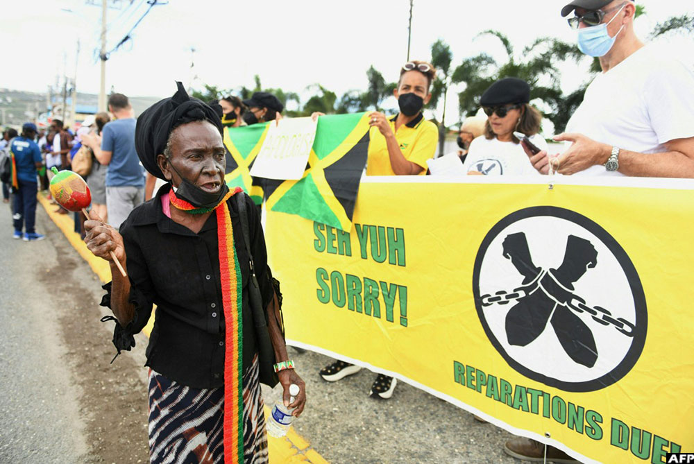  People calling for slavery reparations, protest outside the entrance of the British High Commission in Kingston, Jamaica on March 22, 2022, during the visit of the Britain's Duke and Duchess of Cambridge