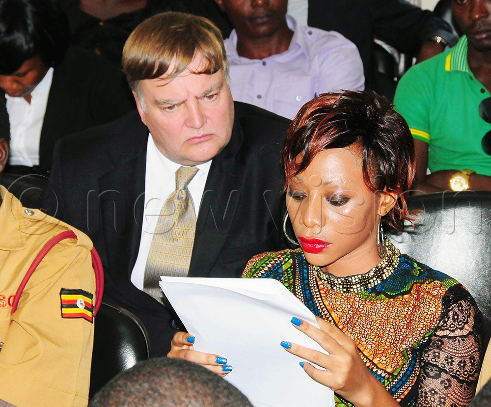 Shanita Namuyimbwa popularly known as Bad Black reading a document with her former lover David Greenhalgh before testifying against Meddie Ssentongo in the Commercial Court on June 25, 2014. (Photo by Nicholas Oneal)