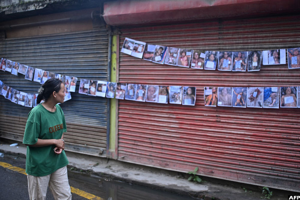 A woman looks at photographs of the missing and dead following flash floods in Nepal, outside a hospital in Kathmandu on August 29, 2026.
